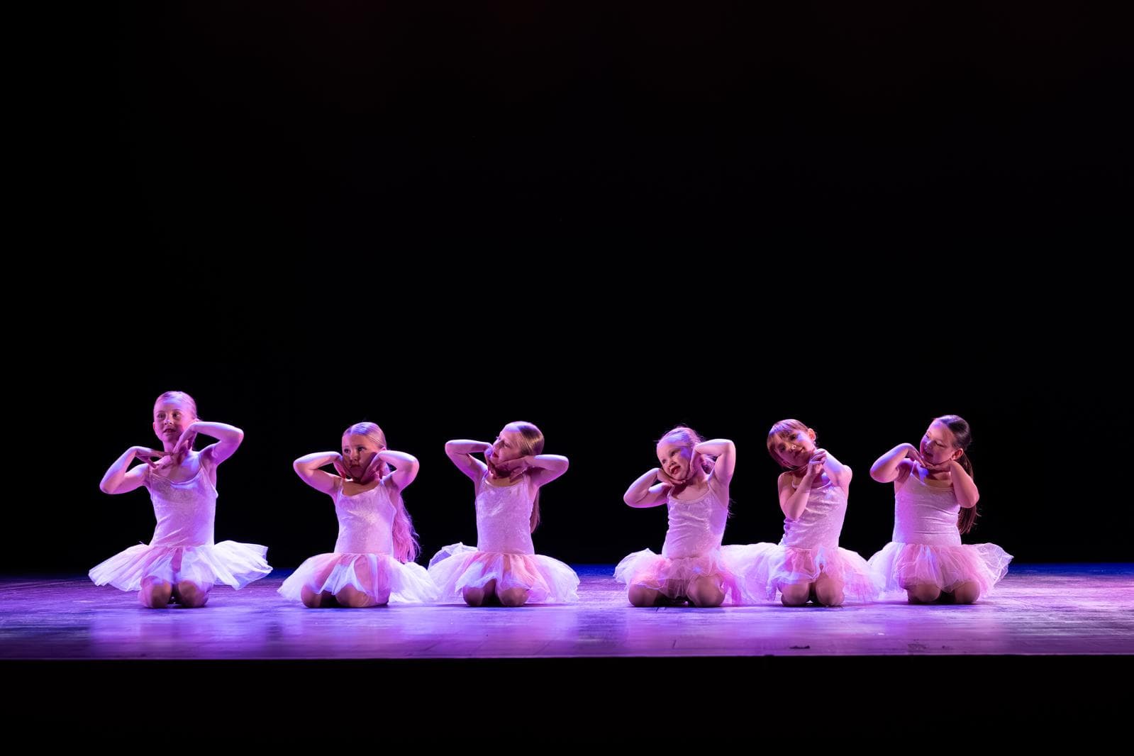Young dancers in tutus celebrating on stage